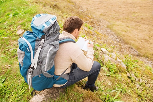 How to Avoid Getting Lost while Hiking — Man with Backpack Taking Notes.