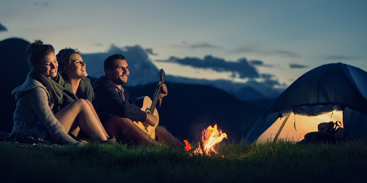 What Is in my Hiking Backpack — Three Friends Camping with Fire on Mountain at Sunset.