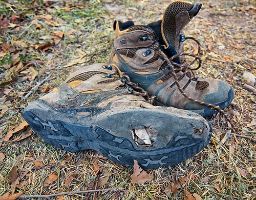 The Best Hiking Boots — Pair of Old Hiking Boots near a Creek.