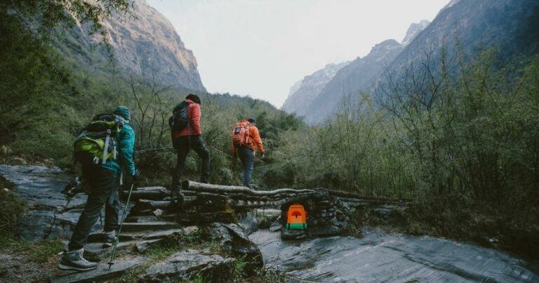 Best Hiking Backpacks Under $100 — Hikers Crossing a Stream.