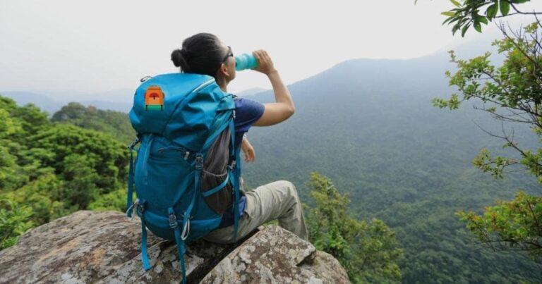 Best Water Bottles for Hiking — Woman Hiker Enjoying the View and Drinking Water.