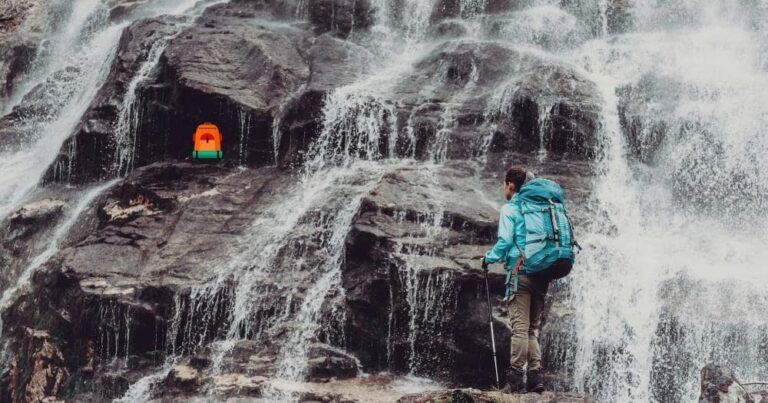 Best Waterproof Backpack — Woman Backpacker in Front of Waterfall.