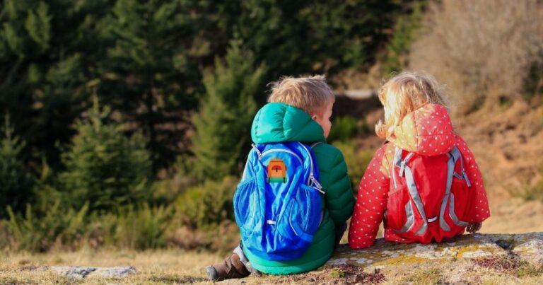 How to Choose a Hiking Backpack — Two Kids Sitting on the Ground.