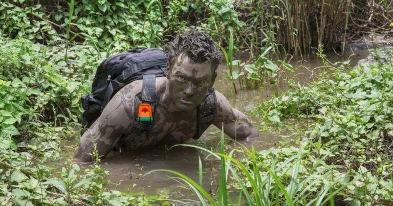 How to Stay Clean When Hiking — Adventurous Man with Backpack in Deep Muddy Water.