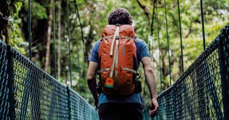Ortlieb Atrack Backpack Review — Man Walking with Backpack on Pedestrian Bridge.