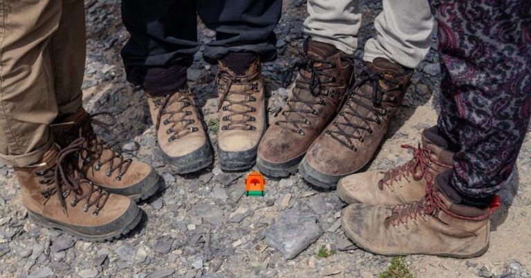 The Best Hiking Boots — Four Tourists in Hiking Boots on Rocky Cliff.