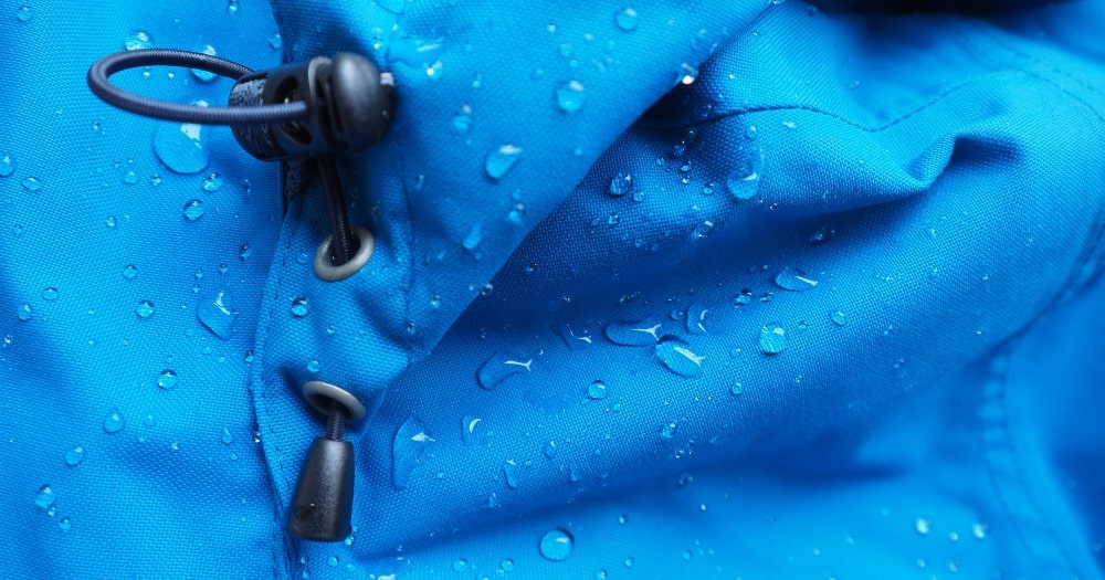 A Closeup of Water Drops on Bright Blue Waterproof Fabrics.